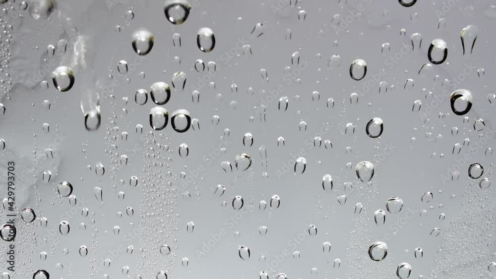 Video of rain and water droplets flowing through clear glass and rain sounds. Video of rain and water droplets flowing through clear glass and rain sounds.