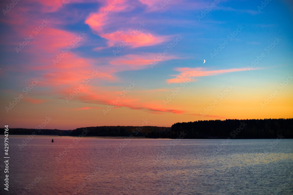 Unusual colorful pink sunset over the lake.