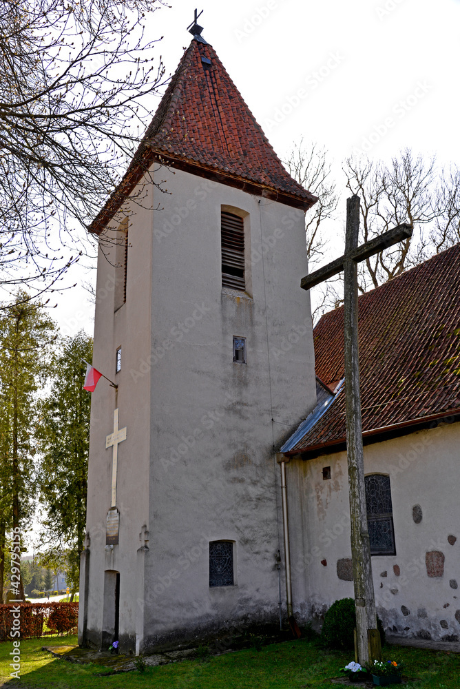 Close-up photos of the architectural details and the belfry of the Catholic church of Saint Józef Rzemielnik built in the 20th century in Nakomiady in Masuria, Poland.