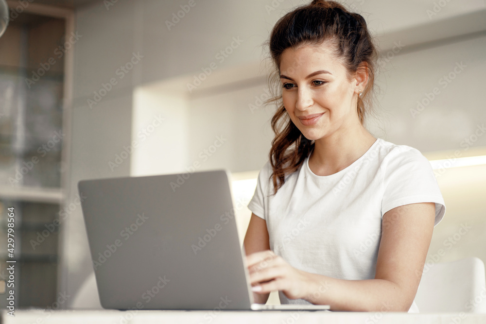 Portrait of a woman sitting at home and typing on a computer text. Orders clothes online at home. A brunette of European appearance. Does work on a new project remotely. Portrait of a woman sitting at home and typing on a computer text. Orders clothes online at home. A brunette of European appearance. Does work on a new project remotely.
