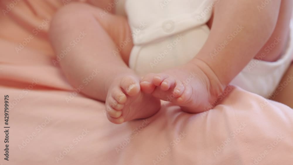 Tiny feet of newborn baby boy closeup 1.5 month old infant lying on mother lap while breastfeeding. High quality 4k footage Tiny feet of newborn baby boy closeup 1.5 month old infant lying on mother lap while breastfeeding. High quality 4k footage