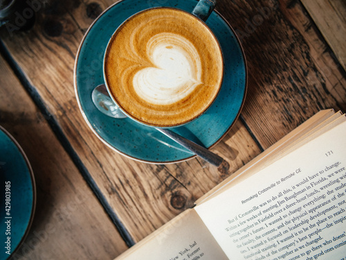 cup of coffee on wooden table with book