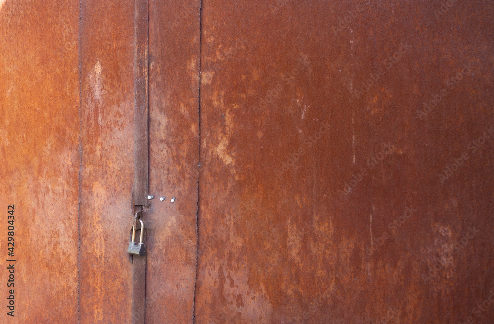 Old metal gate with a key, natural background. Old metal gate with a key, natural background.