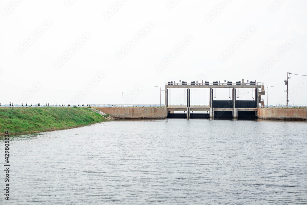 Cement floodgate in earth dam for torrential rains making river overflow, Cement floodgate in earth dam for torrential rains making river overflow,