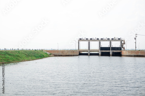 Obraz na plátně Cement floodgate in earth dam for torrential rains making river overflow,