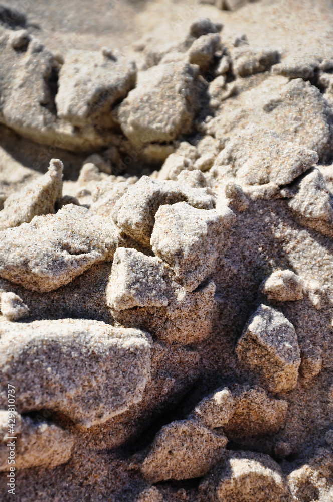 Sandige Oberfläche am Strand. Diese wurde nass und die Oberfläche hat eine brüchige Struktur. Sandige Oberfläche am Strand. Diese wurde nass und die Oberfläche hat eine brüchige Struktur.