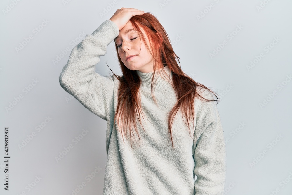 Young red head girl wearing casual winter sweater surprised with hand on head for mistake, remember error. forgot, bad memory concept. Young red head girl wearing casual winter sweater surprised with hand on head for mistake, remember error. forgot, bad memory concept.