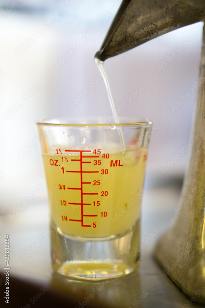Extractor squeeze Thai lemon juice into beaker shot using juice extractor. Extractor squeeze Thai lemon juice into beaker shot using juice extractor.