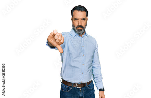 Middle aged man with beard wearing business shirt looking unhappy and angry showing rejection and negative with thumbs down gesture. bad expression.