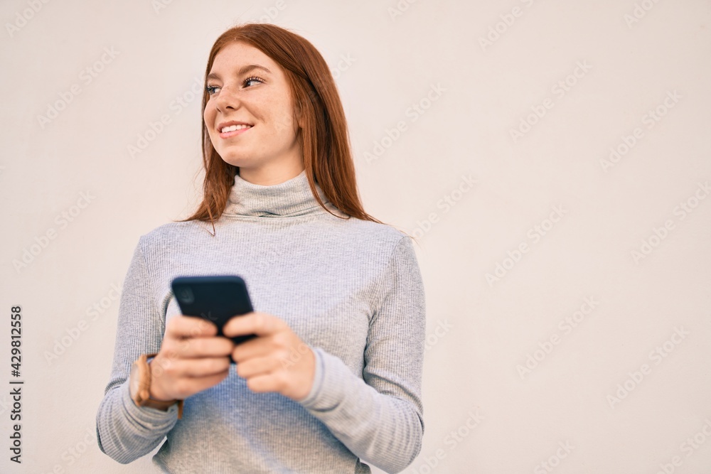Young irish teenager girl smiling happy using smartphone at the city. Young irish teenager girl smiling happy using smartphone at the city.