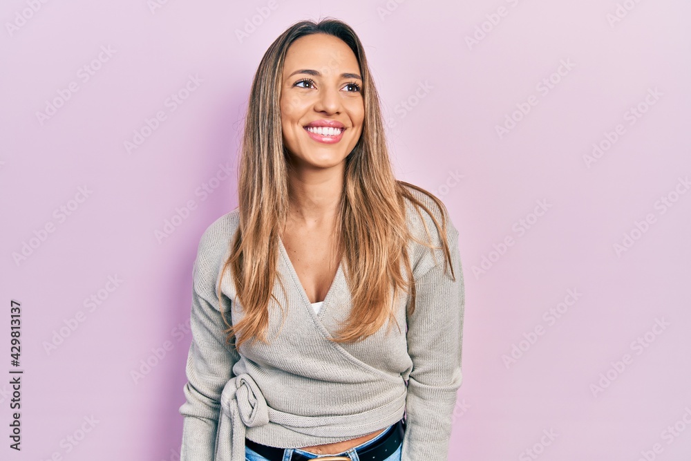 Fototapeta premium Beautiful hispanic woman wearing casual sweater looking to side, relax profile pose with natural face and confident smile.