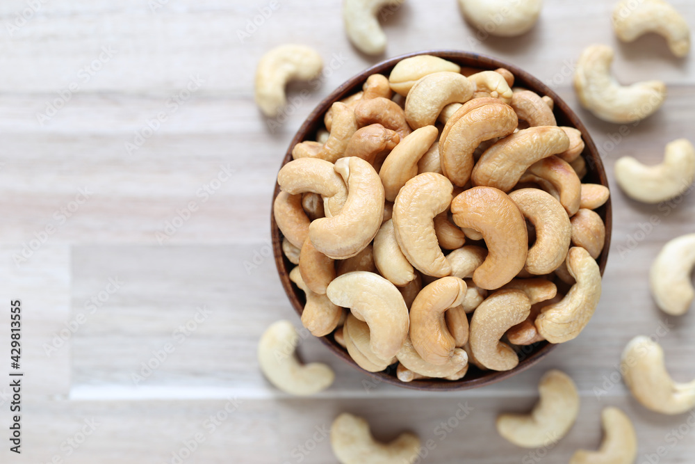 Top view of Roasted cashew nuts in a bowl on wooder background, Healthy eating concept Top view of Roasted cashew nuts in a bowl on wooder background, Healthy eating concept