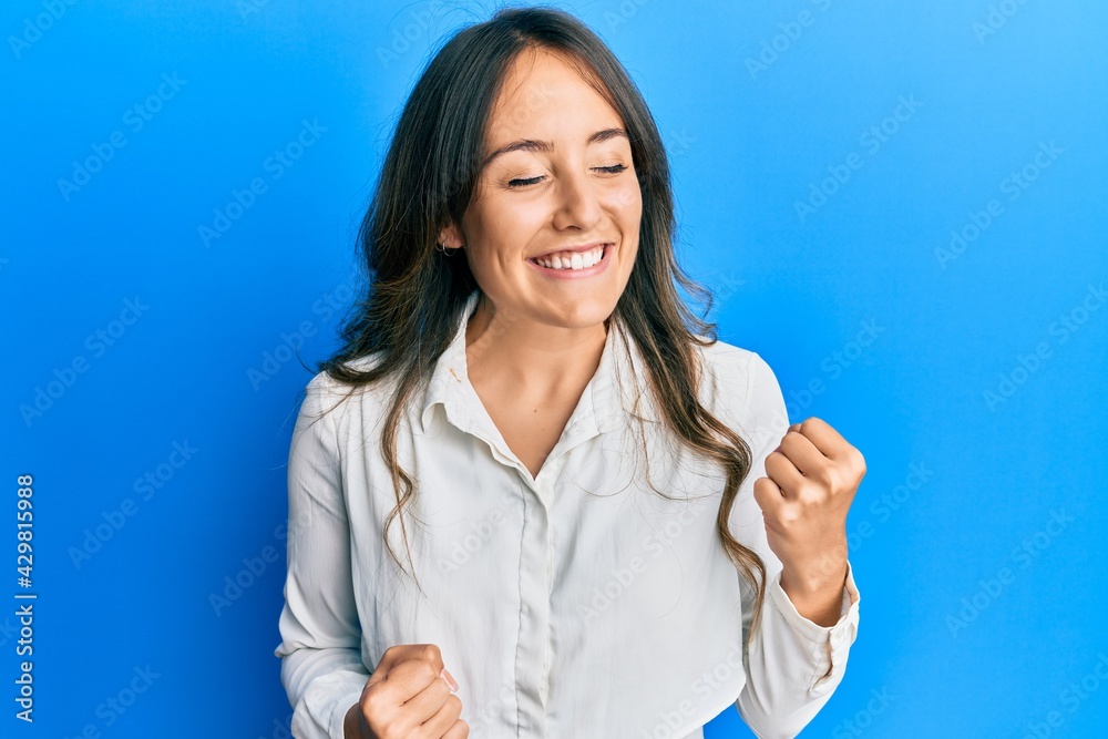 Young brunette woman wearing casual clothes celebrating surprised and amazed for success with arms raised and eyes closed Young brunette woman wearing casual clothes celebrating surprised and amazed for success with arms raised and eyes closed