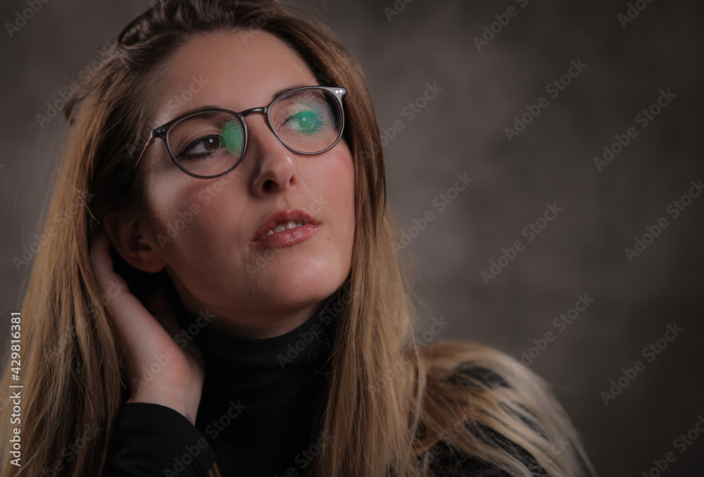 Close-up of a young attractive woman against dark grey background - studio photography Close-up of a young attractive woman against dark grey background - studio photography