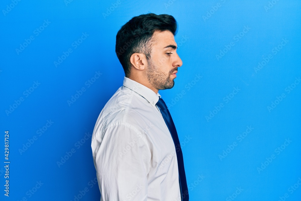 Young hispanic man wearing business clothes looking to side, relax profile pose with natural face with confident smile. Young hispanic man wearing business clothes looking to side, relax profile pose with natural face with confident smile.