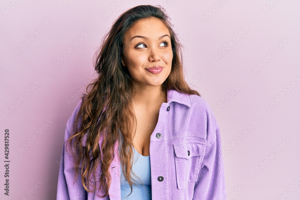 Young hispanic girl wearing casual clothes smiling looking to the side and staring away thinking. Young hispanic girl wearing casual clothes smiling looking to the side and staring away thinking.