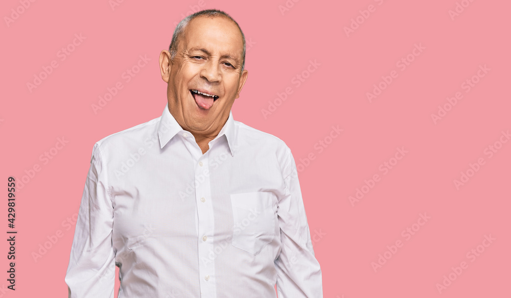 Handsome senior man wearing elegant white shirt sticking tongue out happy with funny expression. emotion concept. Handsome senior man wearing elegant white shirt sticking tongue out happy with funny expression. emotion concept.