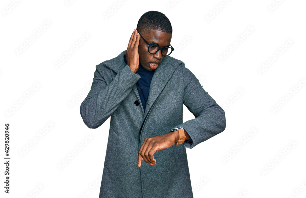 Young african american man wearing business clothes and glasses looking at the watch time worried, afraid of getting late Young african american man wearing business clothes and glasses looking at the watch time worried, afraid of getting late