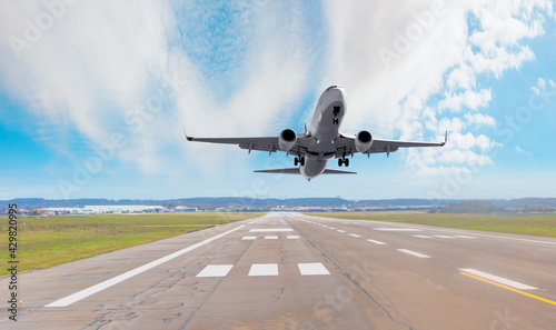 White Passenger plane fly up over take-off runway from airport 