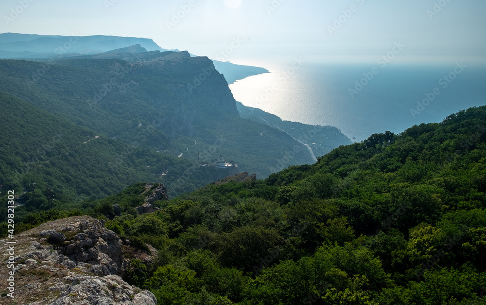 Mediterranean landscape. Forested rocks of the Black Sea coast of the southern coast of the Crimean Peninsula on a clear sunny day.