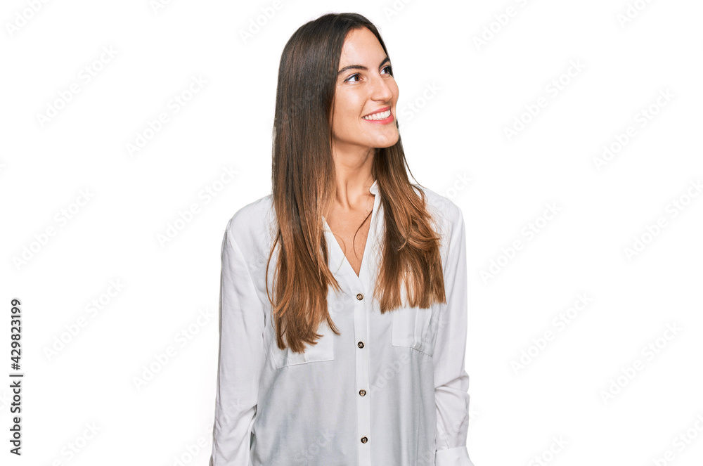 Young beautiful woman wearing casual clothes looking away to side with smile on face, natural expression. laughing confident. Young beautiful woman wearing casual clothes looking away to side with smile on face, natural expression. laughing confident.