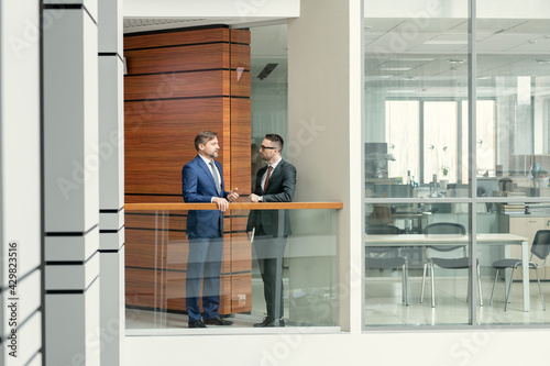 Businessmen talking in corridor © pressmaster