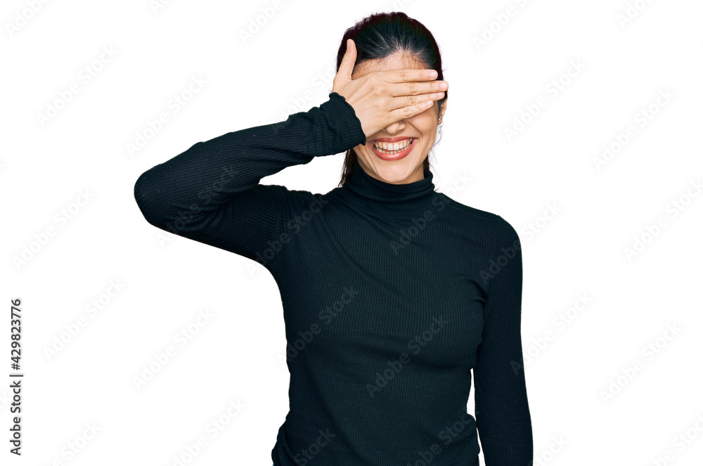 Young hispanic woman wearing casual clothes smiling and laughing with hand on face covering eyes for surprise. blind concept.