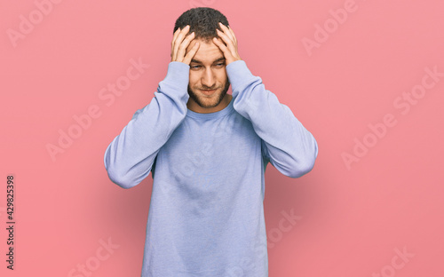 Young caucasian man wearing casual clothes with hand on head for pain in head because stress. suffering migraine.