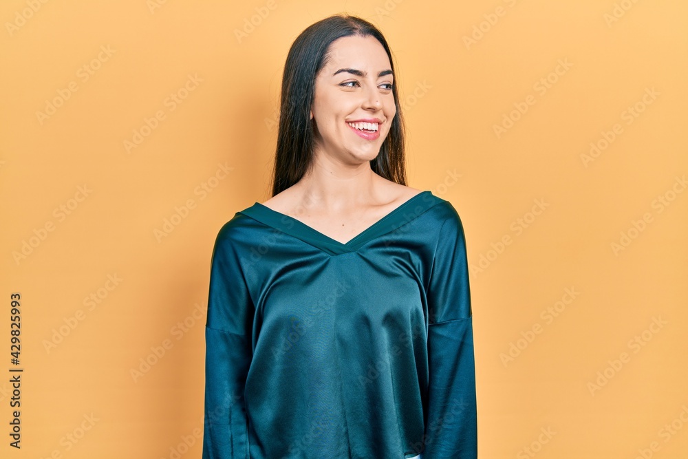 Beautiful woman with blue eyes wearing elegant shirt looking away to side with smile on face, natural expression. laughing confident.