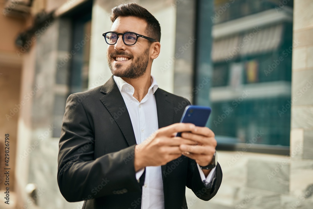 Young hispanic businessman smiling happy using smartphone at the city. Young hispanic businessman smiling happy using smartphone at the city.
