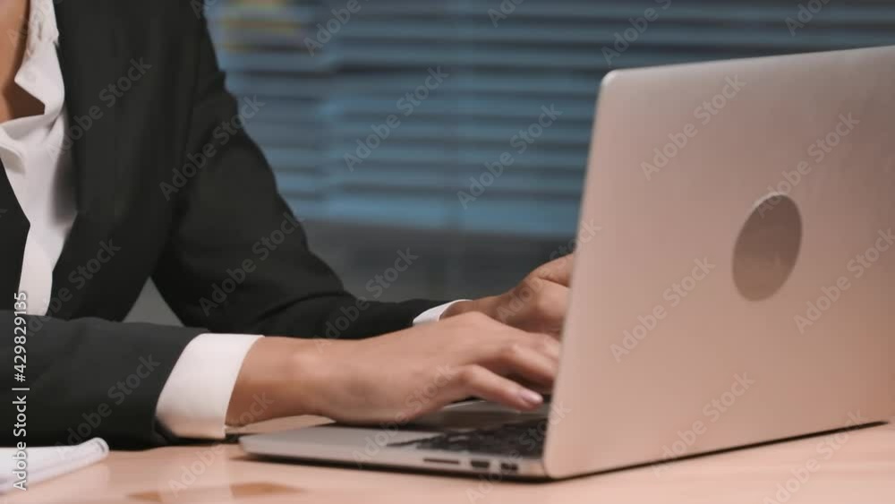 Portrait of African American woman makes an online purchase using credit card and laptop. Businesswoman posing at workplace, sitting at table in office. Close up. Slow motion ready, 4K at 59.94fps. Portrait of African American woman makes an online purchase using credit card and laptop. Businesswoman posing at workplace, sitting at table in office. Close up. Slow motion ready, 4K at 59.94fps.
