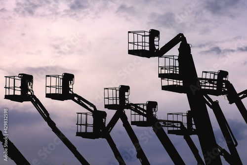 Silhouettes of aerial work platforms (AWP), also known as aerial devices, elevating work platforms (EWP), cherry pickers, bucket trucks or mobile elevating work platforms (MEWP).