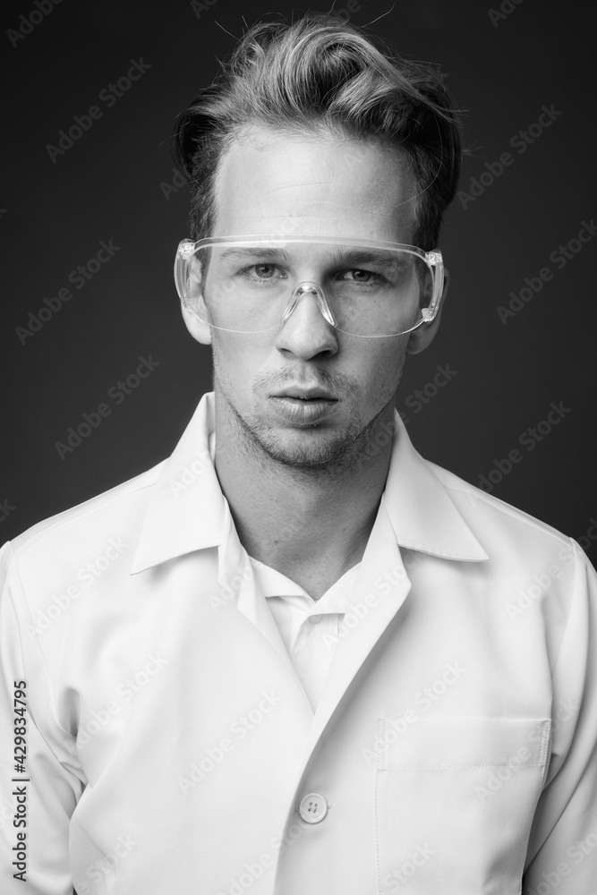 Young handsome man doctor as scientist with protective glasses Young handsome man doctor as scientist with protective glasses