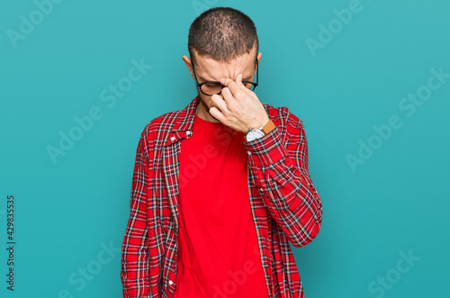 Hispanic young man wearing casual clothes tired rubbing nose and eyes feeling fatigue and headache. stress and frustration concept.