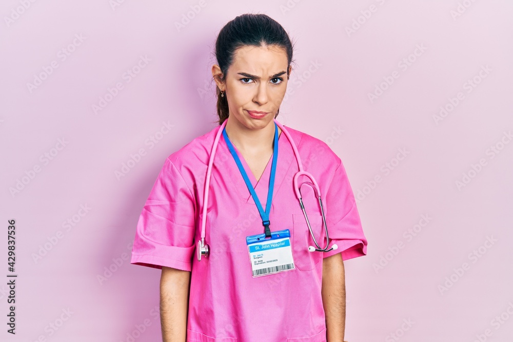Young brunette woman wearing doctor uniform and stethoscope skeptic and nervous, frowning upset because of problem. negative person. Young brunette woman wearing doctor uniform and stethoscope skeptic and nervous, frowning upset because of problem. negative person.