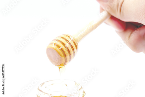 Hand held wooden honey ladle , isolated on white background