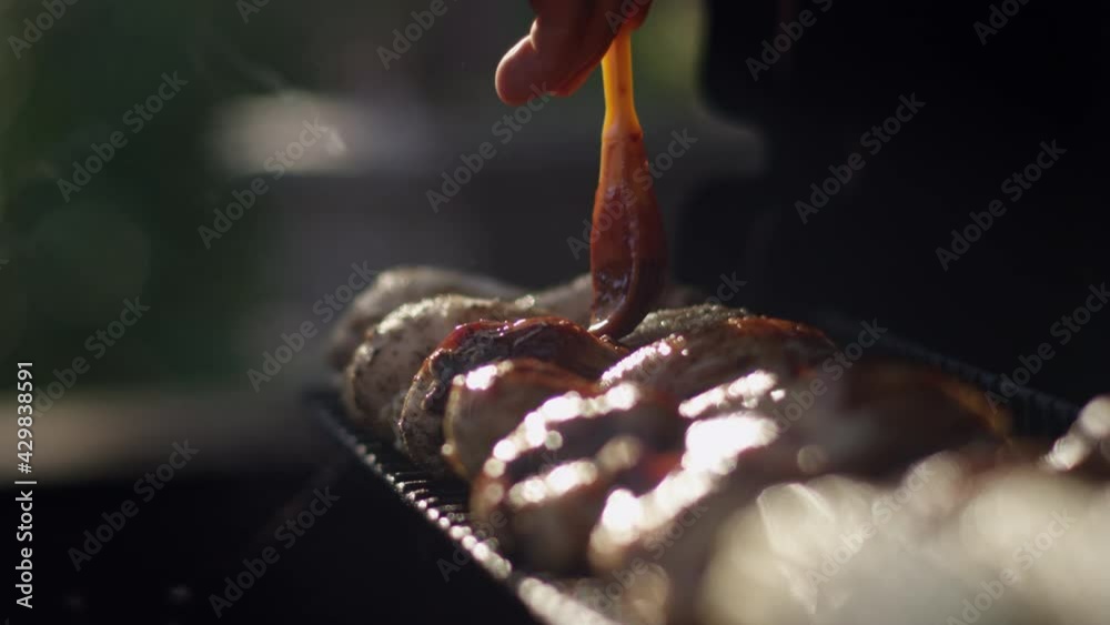 Bbq grillmaster slathers juicy chicken with sauce