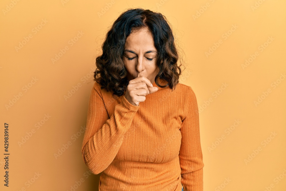 Middle age hispanic woman wearing casual clothes feeling unwell and coughing as symptom for cold or bronchitis. health care concept. Middle age hispanic woman wearing casual clothes feeling unwell and coughing as symptom for cold or bronchitis. health care concept.