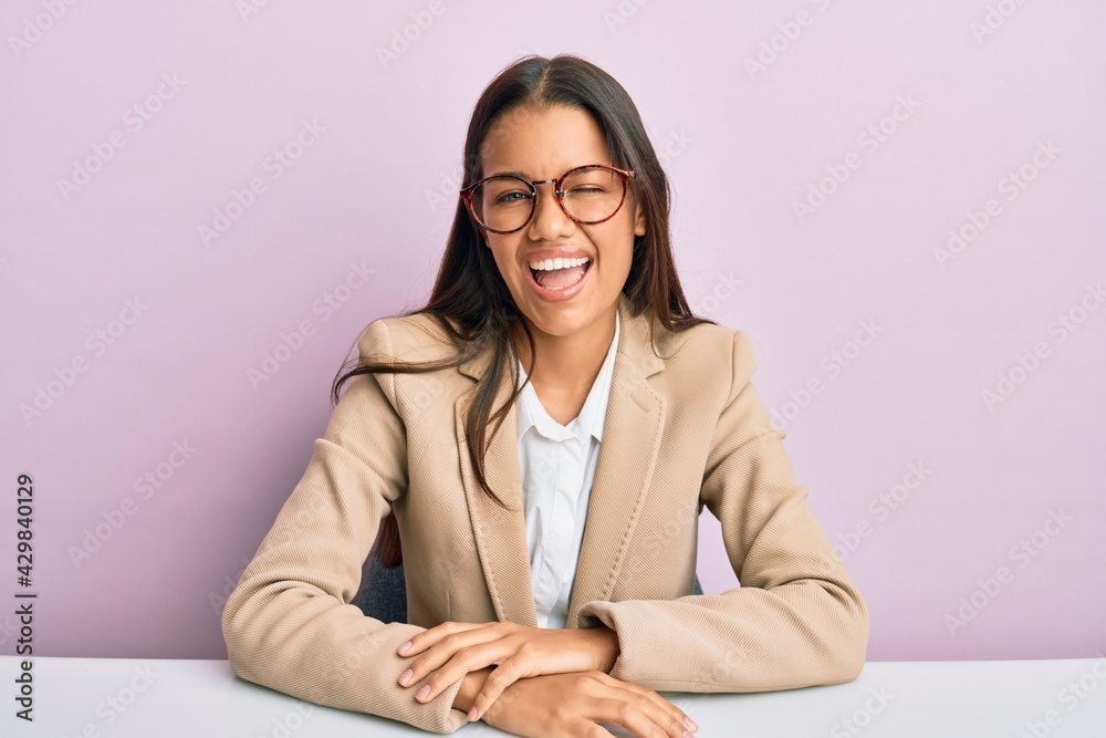 Beautiful hispanic woman working at the office winking looking at the camera with sexy expression, cheerful and happy face. Beautiful hispanic woman working at the office winking looking at the camera with sexy expression, cheerful and happy face.