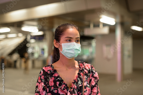 Woman wearing face mask for protection against coronavirus Covid-19 outdoors at night