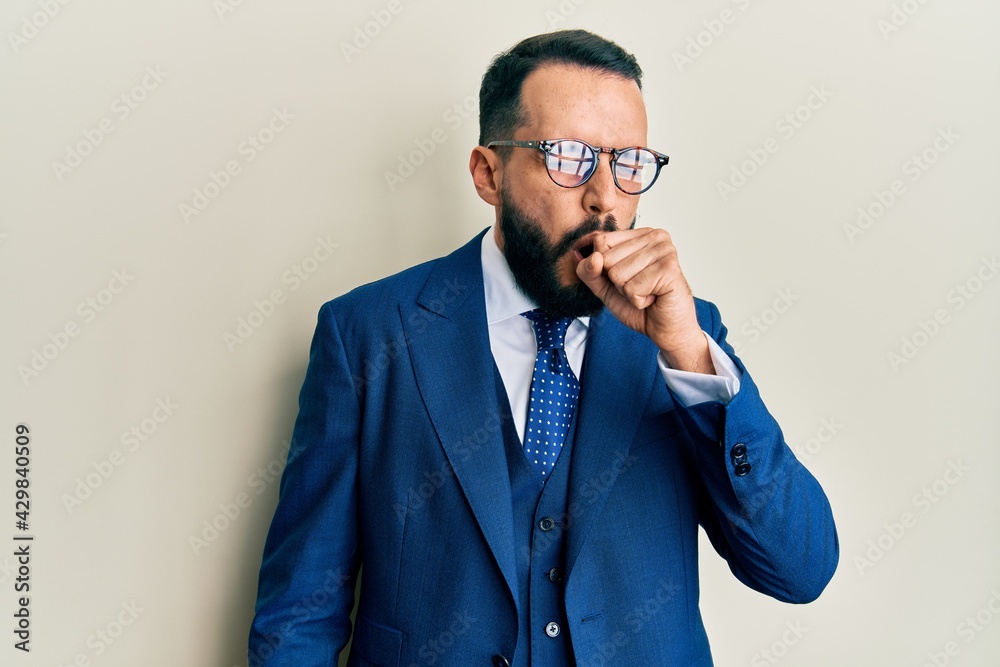 Young man with beard wearing business suit and tie feeling unwell and coughing as symptom for cold or bronchitis. health care concept. Young man with beard wearing business suit and tie feeling unwell and coughing as symptom for cold or bronchitis. health care concept.