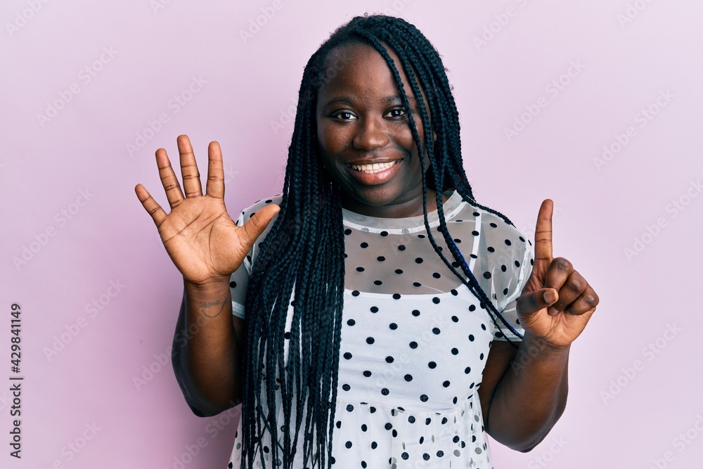 Young black woman with braids wearing casual clothes showing and pointing up with fingers number six while smiling confident and happy. Young black woman with braids wearing casual clothes showing and pointing up with fingers number six while smiling confident and happy.