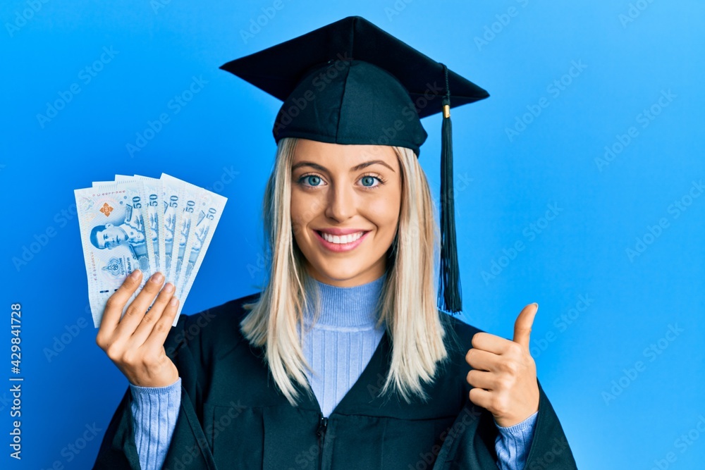 Graduation Excellent Beautiful blonde woman wearing graduation cap and ceremony robe holding ...