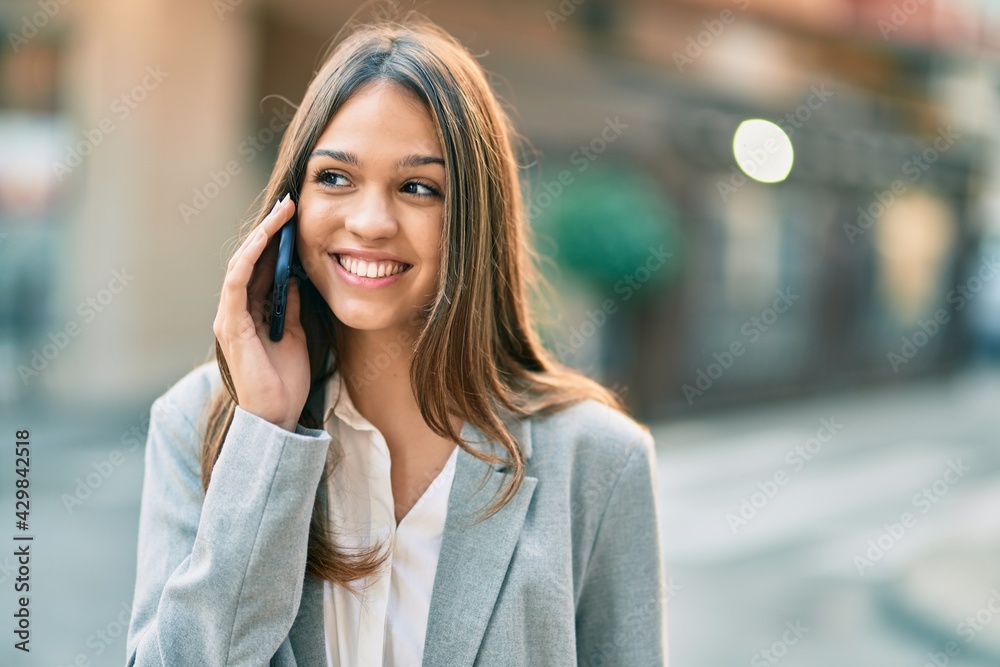 Young latin businesswoman smiling happy talking on the smartphone at the city. Young latin businesswoman smiling happy talking on the smartphone at the city.