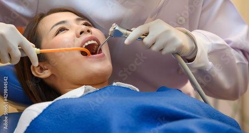 Dentist treatment teeth cavity with Patient while holding air water syringe machine at dental clinic office  Professional treatment at dental clinic and teeth care with copy space.