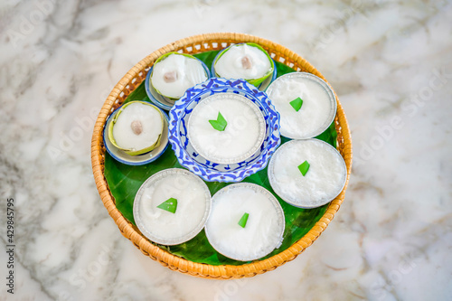 Luxury Dessert, Khanom thuai is Thai dessert coconut milk pudding was arranged in the wicker set on the marble table. photo