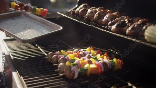 Grillmaster places his famous shish kabobs on the smoking grill