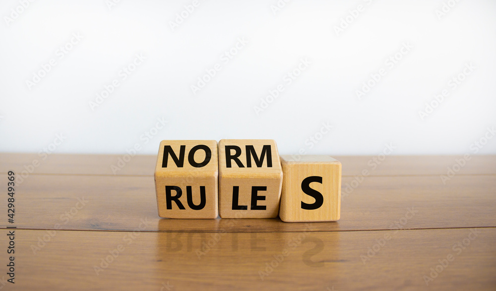 Rules or norms symbol. Turned cubes and changed the word 'norms' to 'rules'. Beautiful wooden table, white background, copy space. Business and rules or norms concept. - obrazy, fototapety, plakaty 