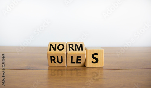 Rules or norms symbol. Turned cubes and changed the word 'norms' to 'rules'. Beautiful wooden table, white background, copy space. Business and rules or norms concept. photo