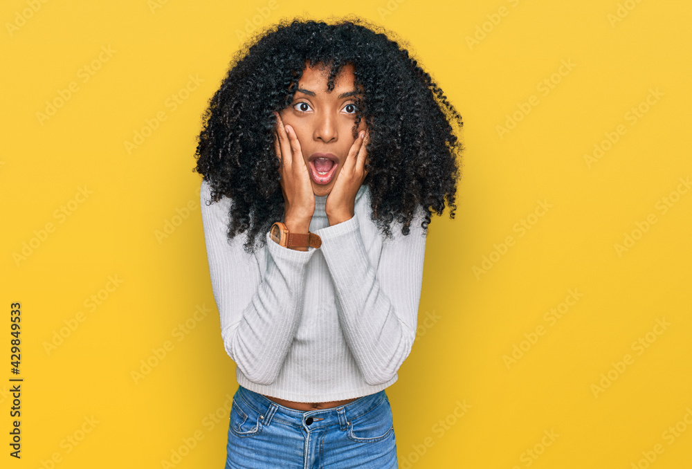 Young african american girl wearing casual clothes afraid and shocked, surprise and amazed expression with hands on face Young african american girl wearing casual clothes afraid and shocked, surprise and amazed expression with hands on face